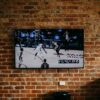 black flat screen tv mounted on brown brick wall