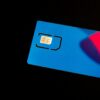 A blue sim card sits on a dark surface.